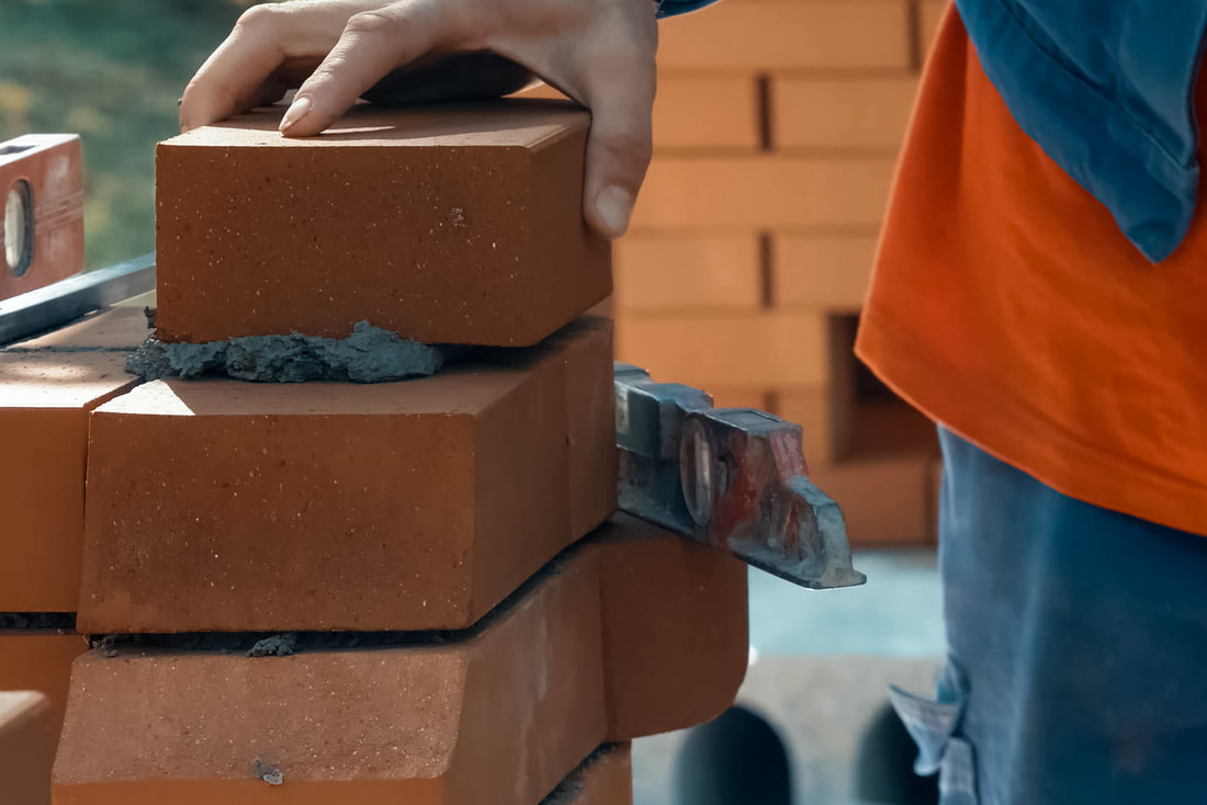 man installing brick walls