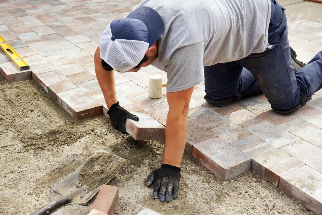 man installing brick flooring